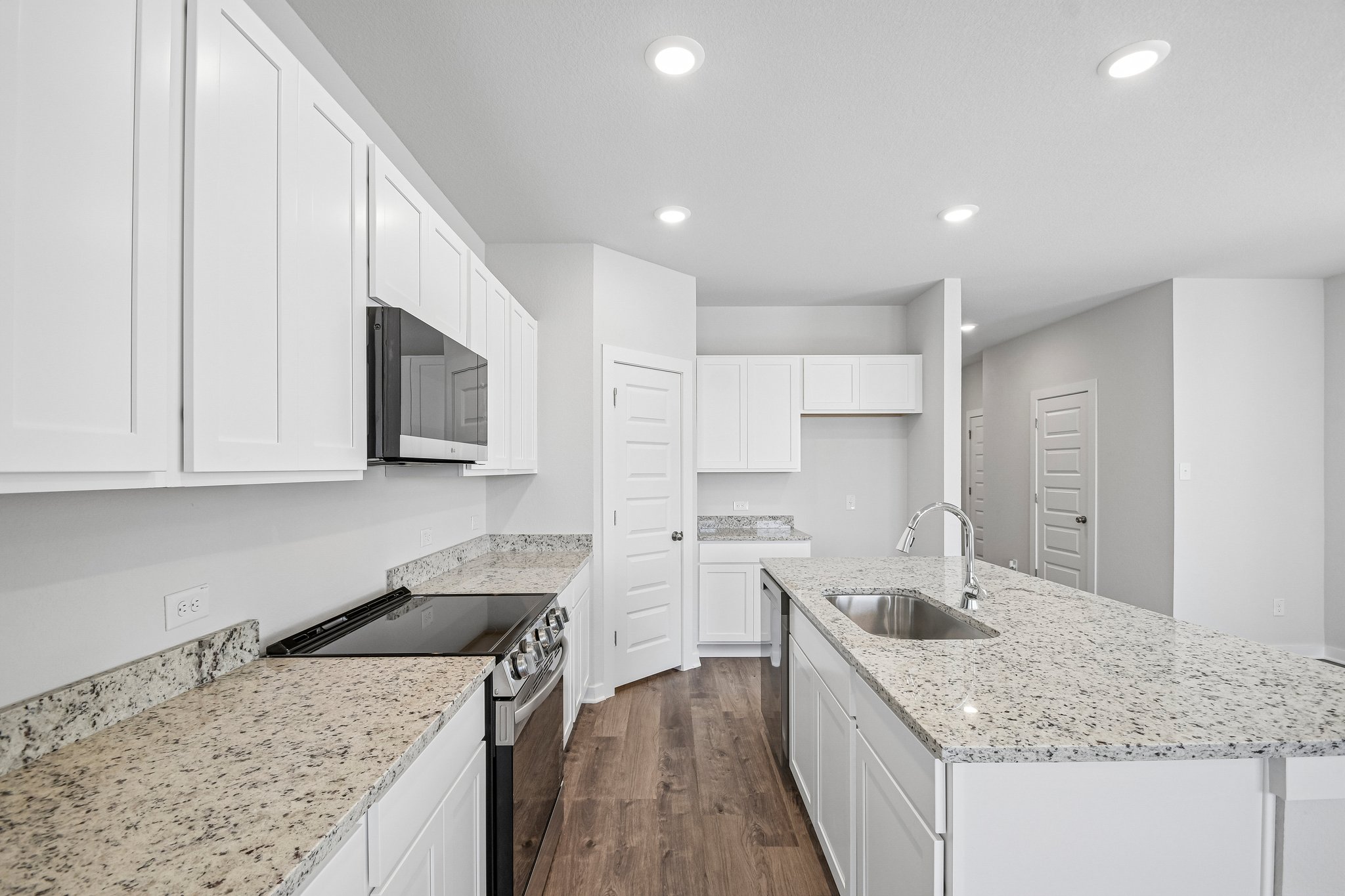A kitchen with white cabinets.