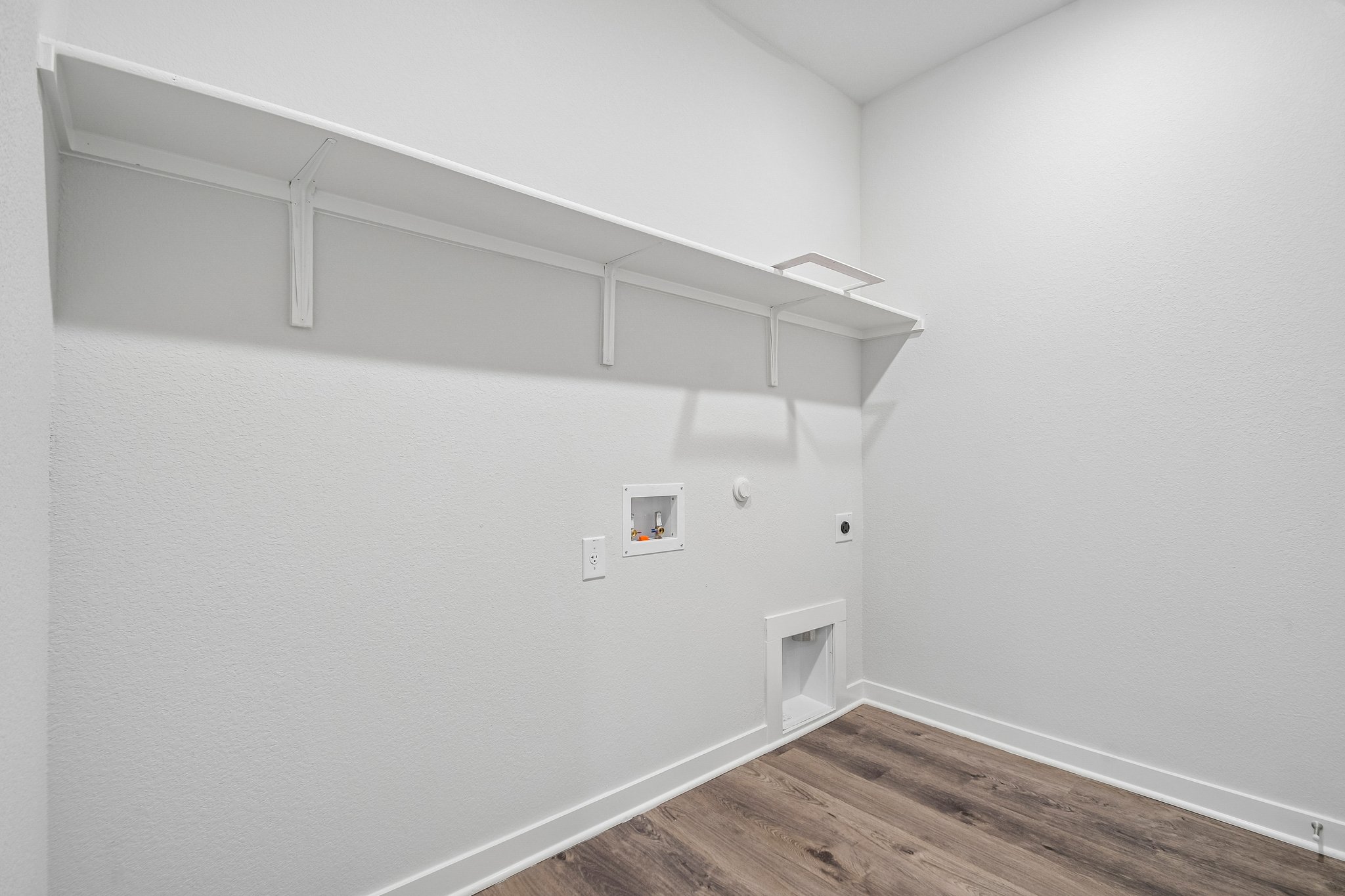 A white room with a wood floor.