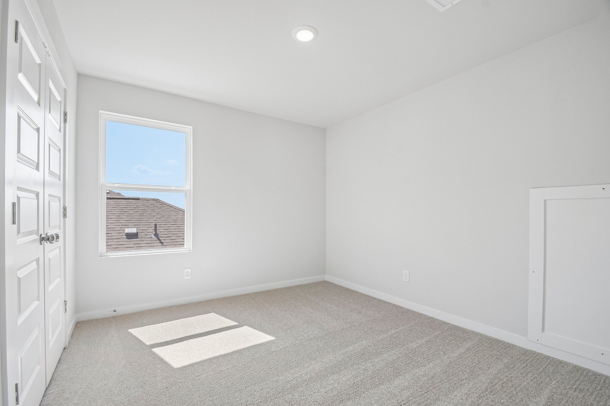 A room with white walls and a window.