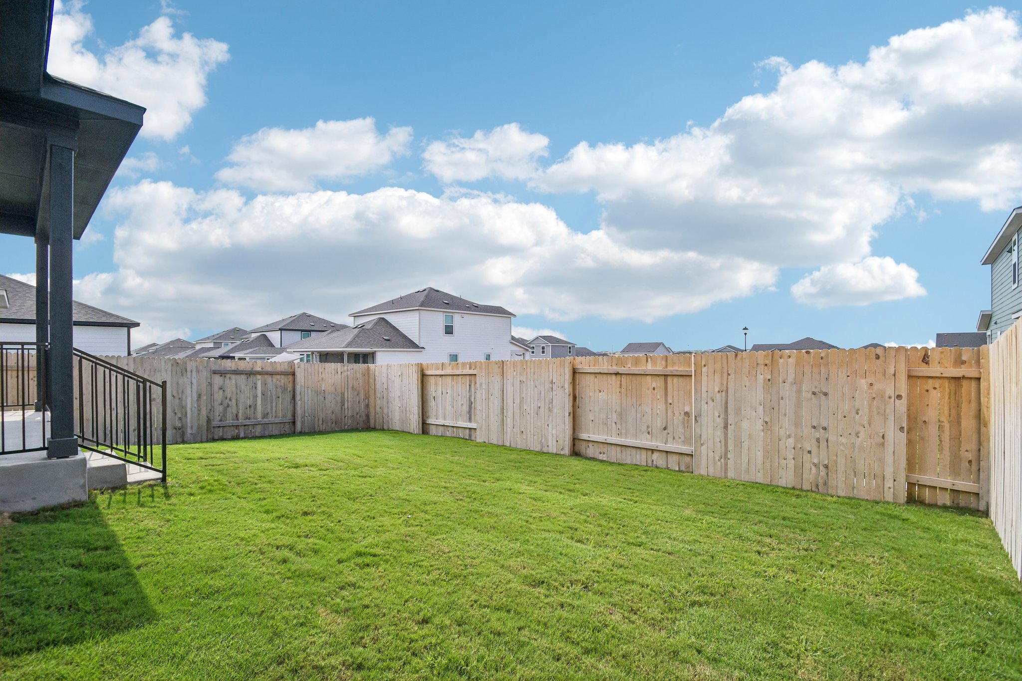 A fenced in yard with a house in the background.