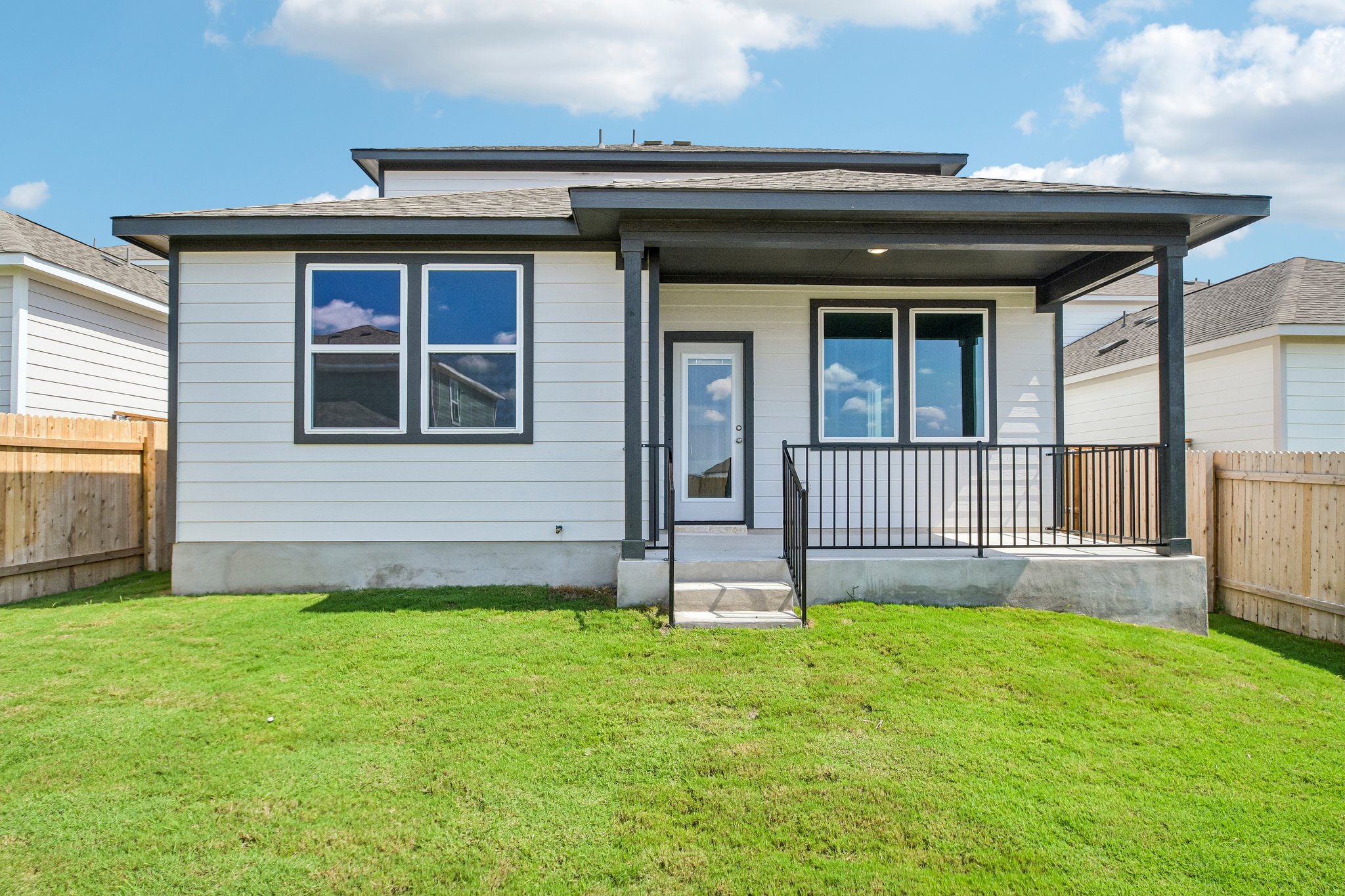 A house with a fence and grass.