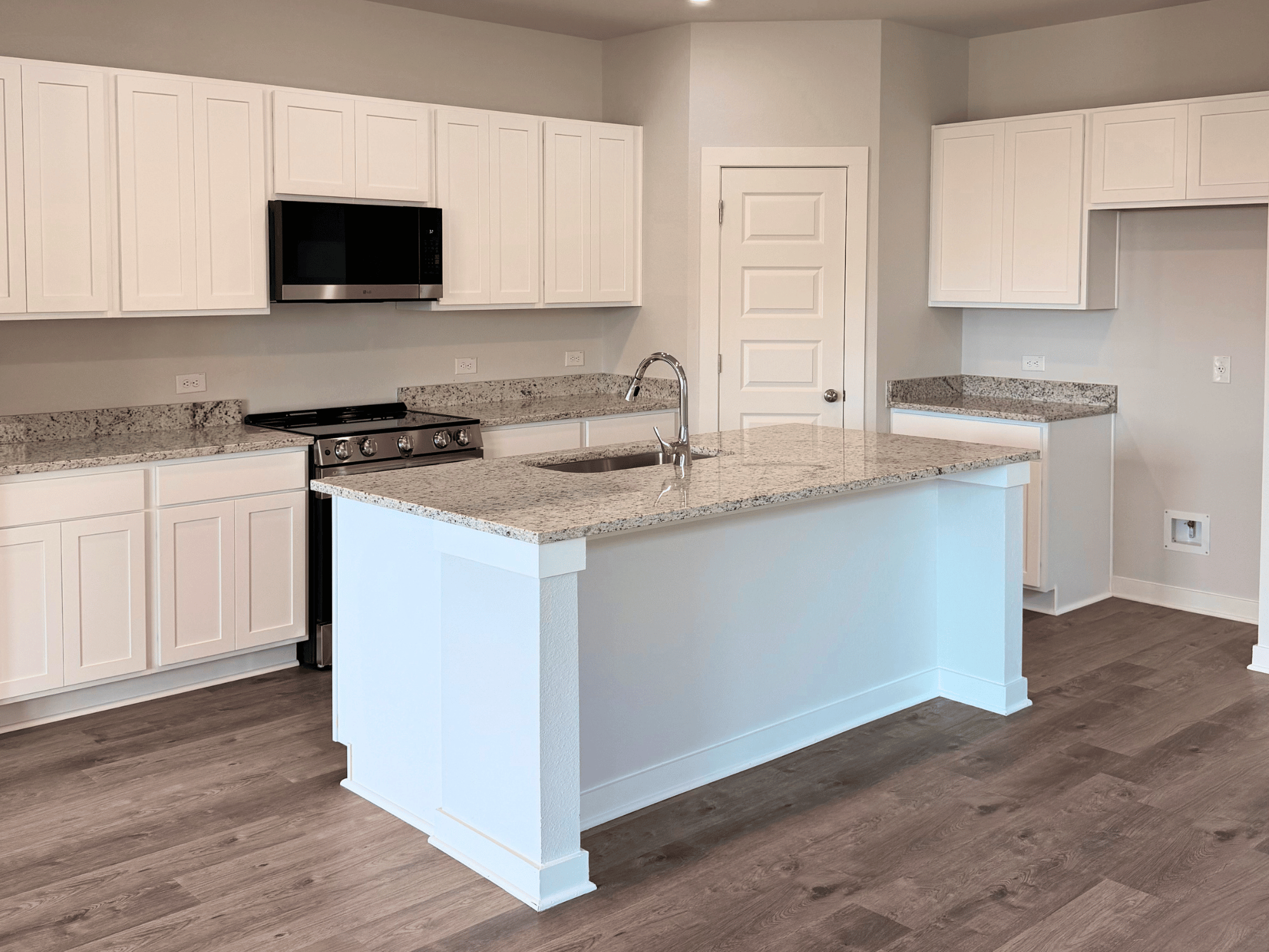 A kitchen with white cabinets.