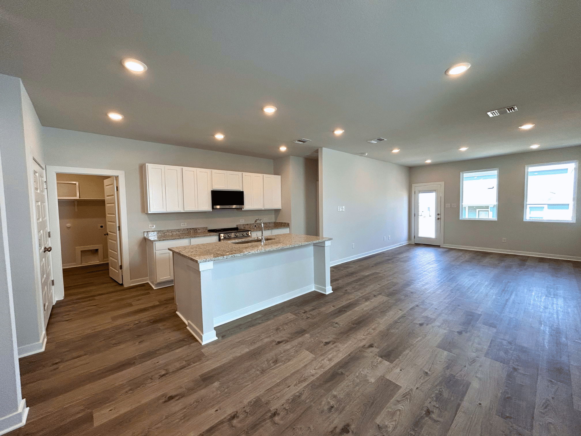 A large kitchen with a wood floor.