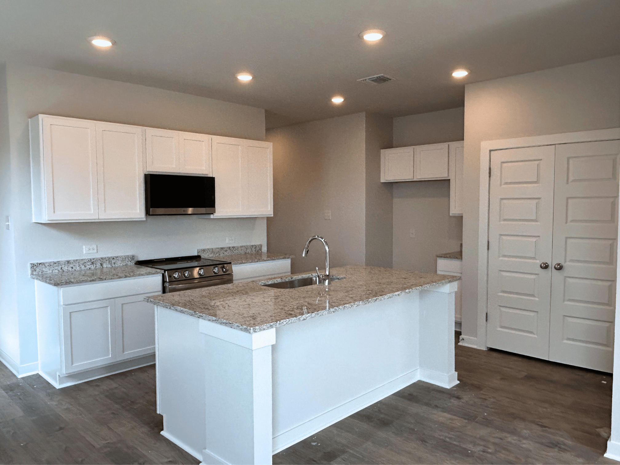 A kitchen with white cabinets.