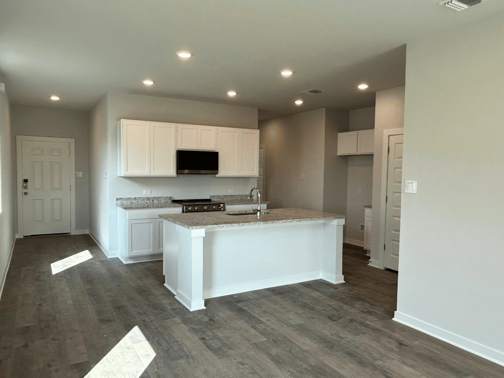 A kitchen with white cabinets.