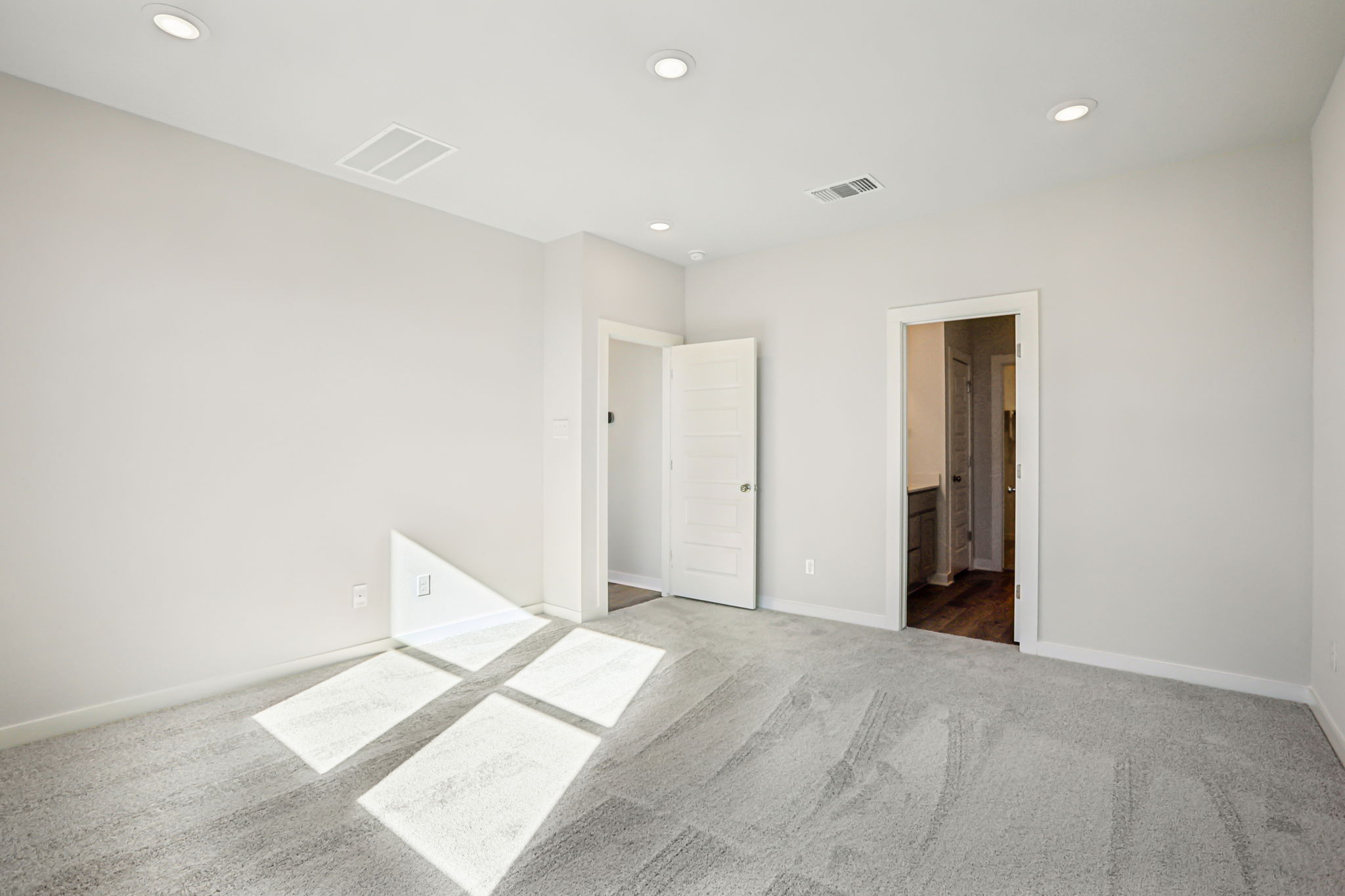 A room with white walls and a rug.