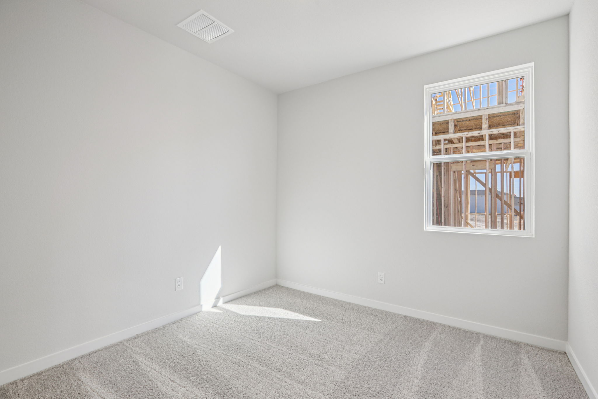 A room with a window and a rug.