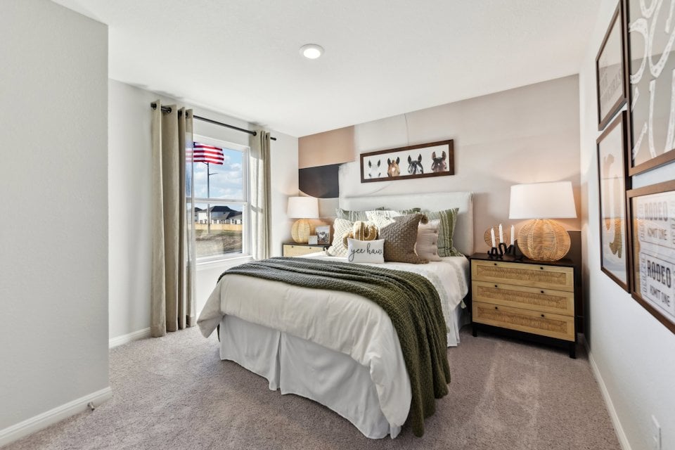 A bedroom with a bed and lamps.