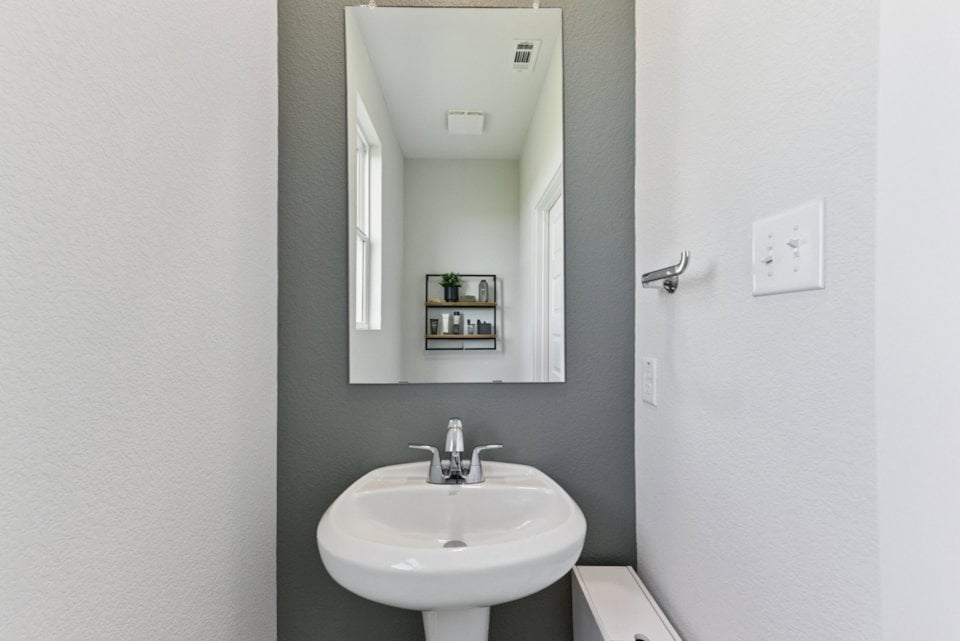 A bathroom with a mirror and sink.