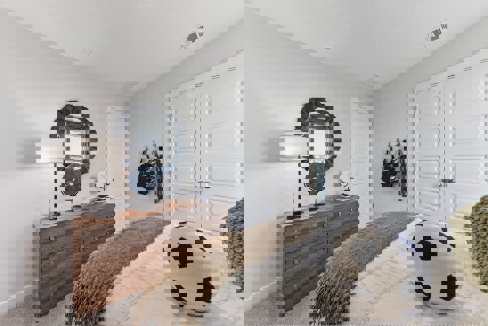 A bedroom with a mirror and a bed.