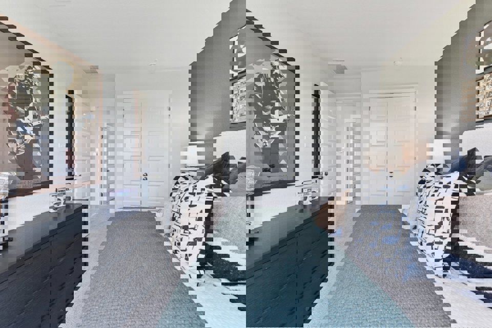 A bedroom with a bed and a dresser.