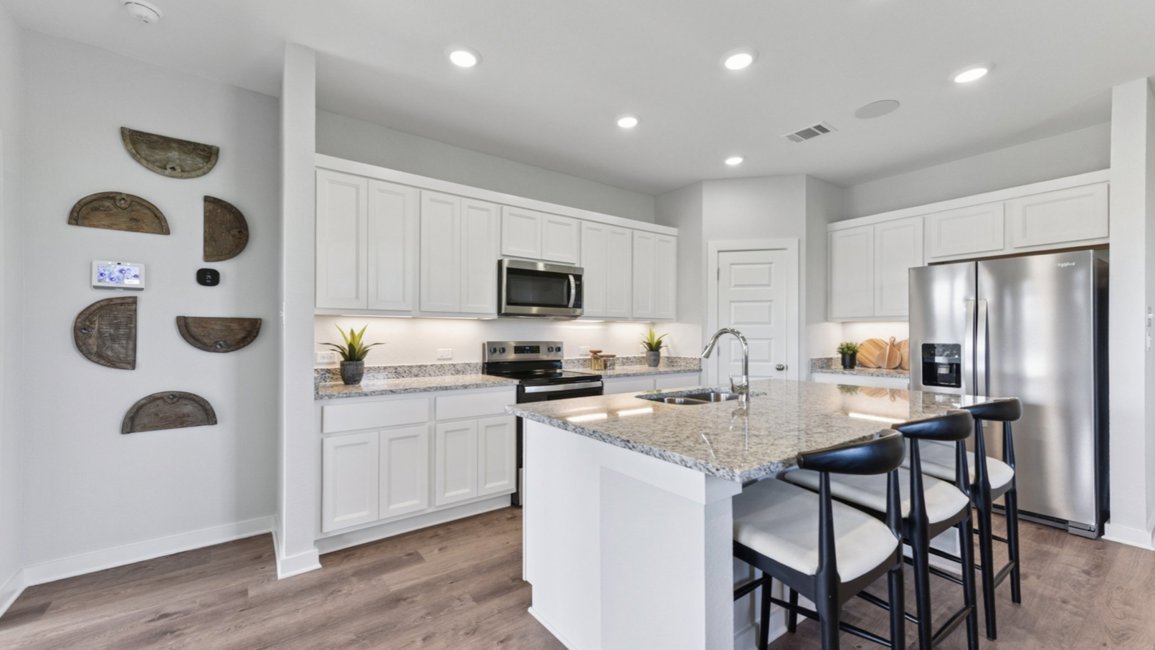 A kitchen with white cabinets.