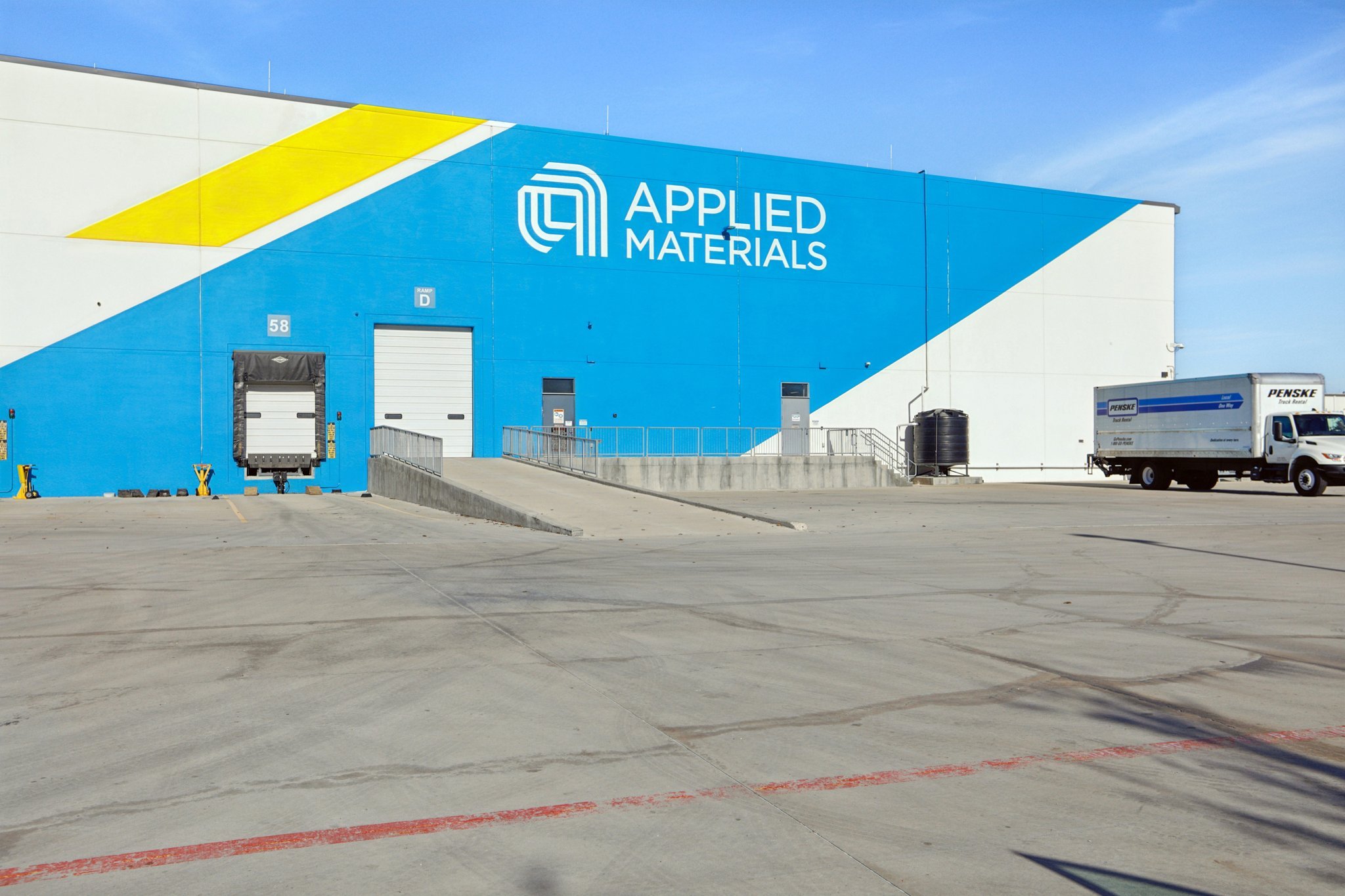 A large white building with a blue sign on it.