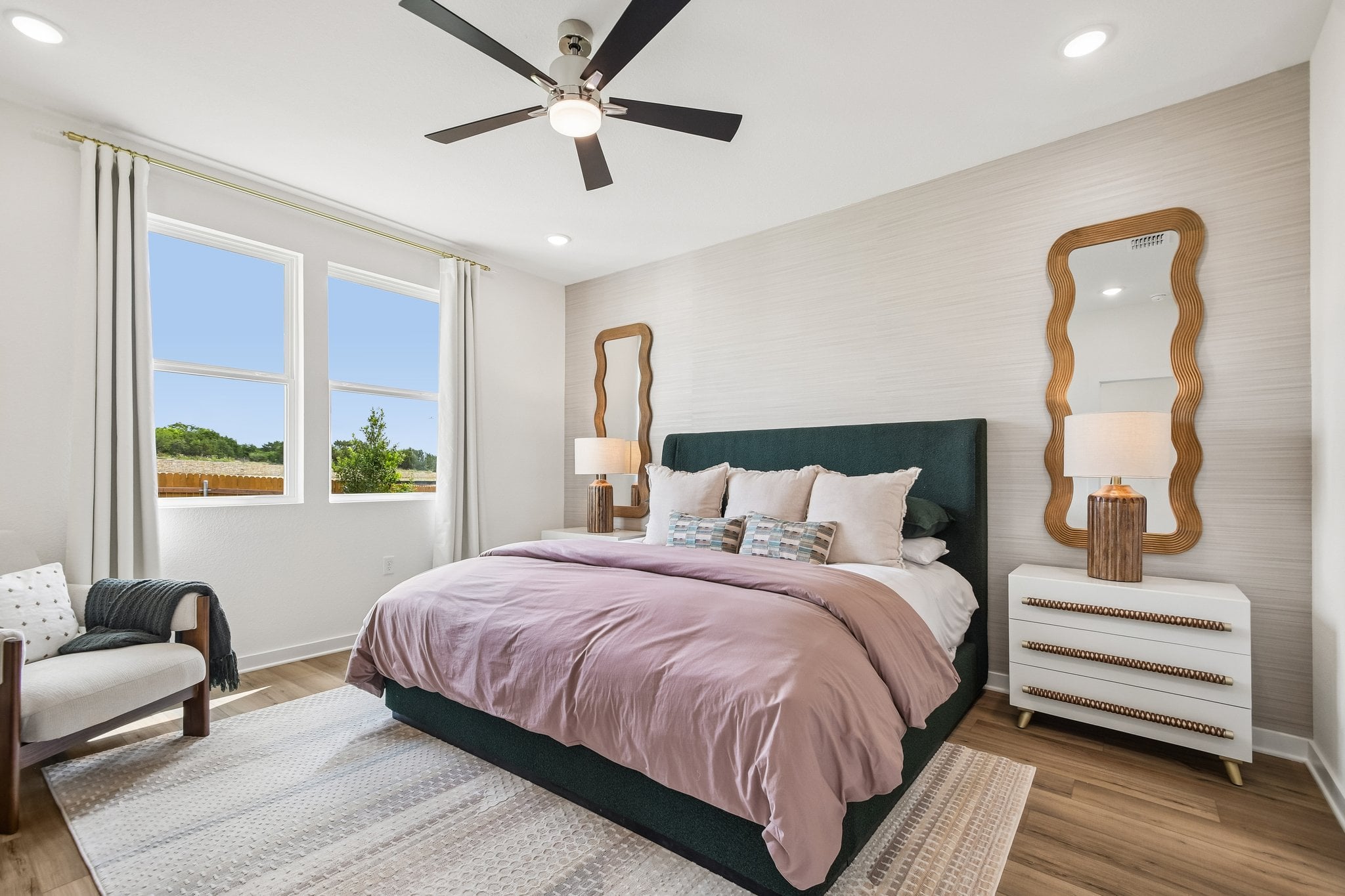 A bedroom with a large bed and a fan.