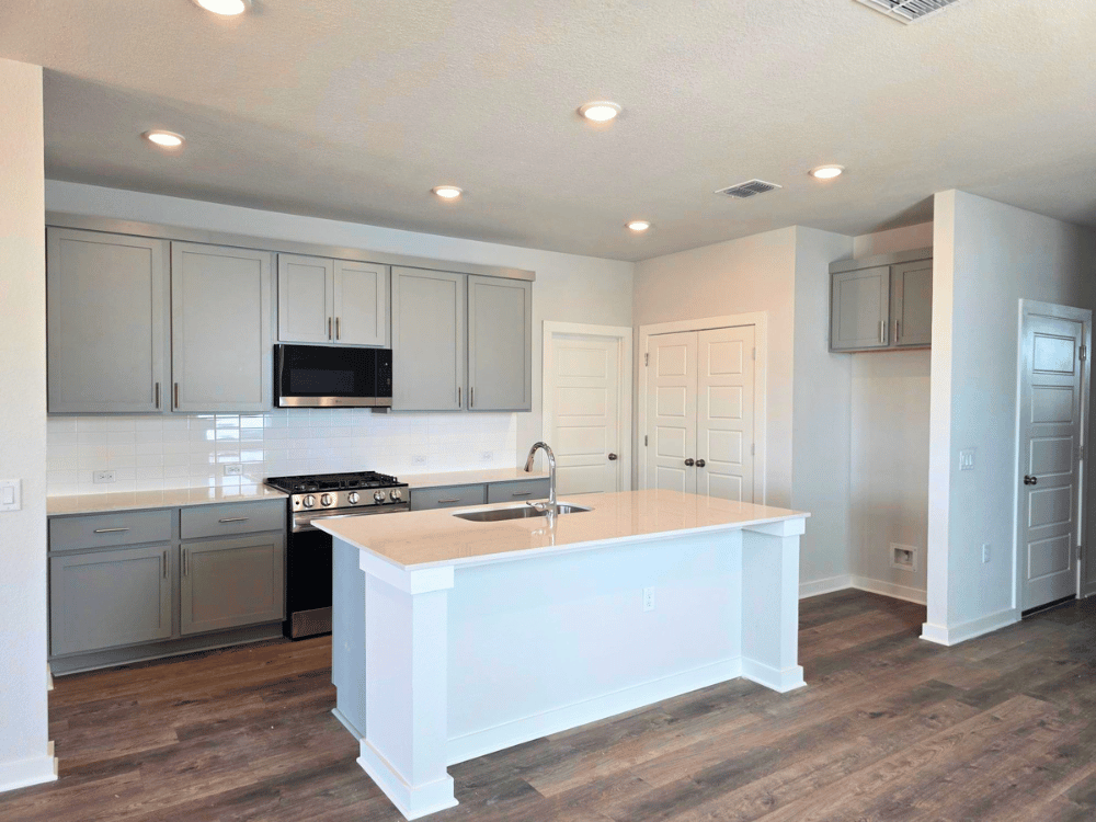 A kitchen with white cabinets.