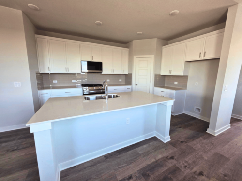 A kitchen with white cabinets.