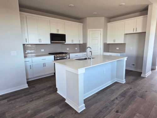 A kitchen with white cabinets.