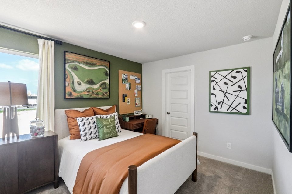 A bedroom with a bed and a chair.