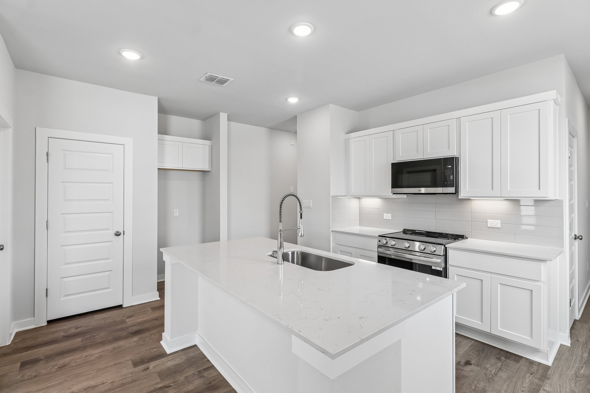 A kitchen with white cabinets.
