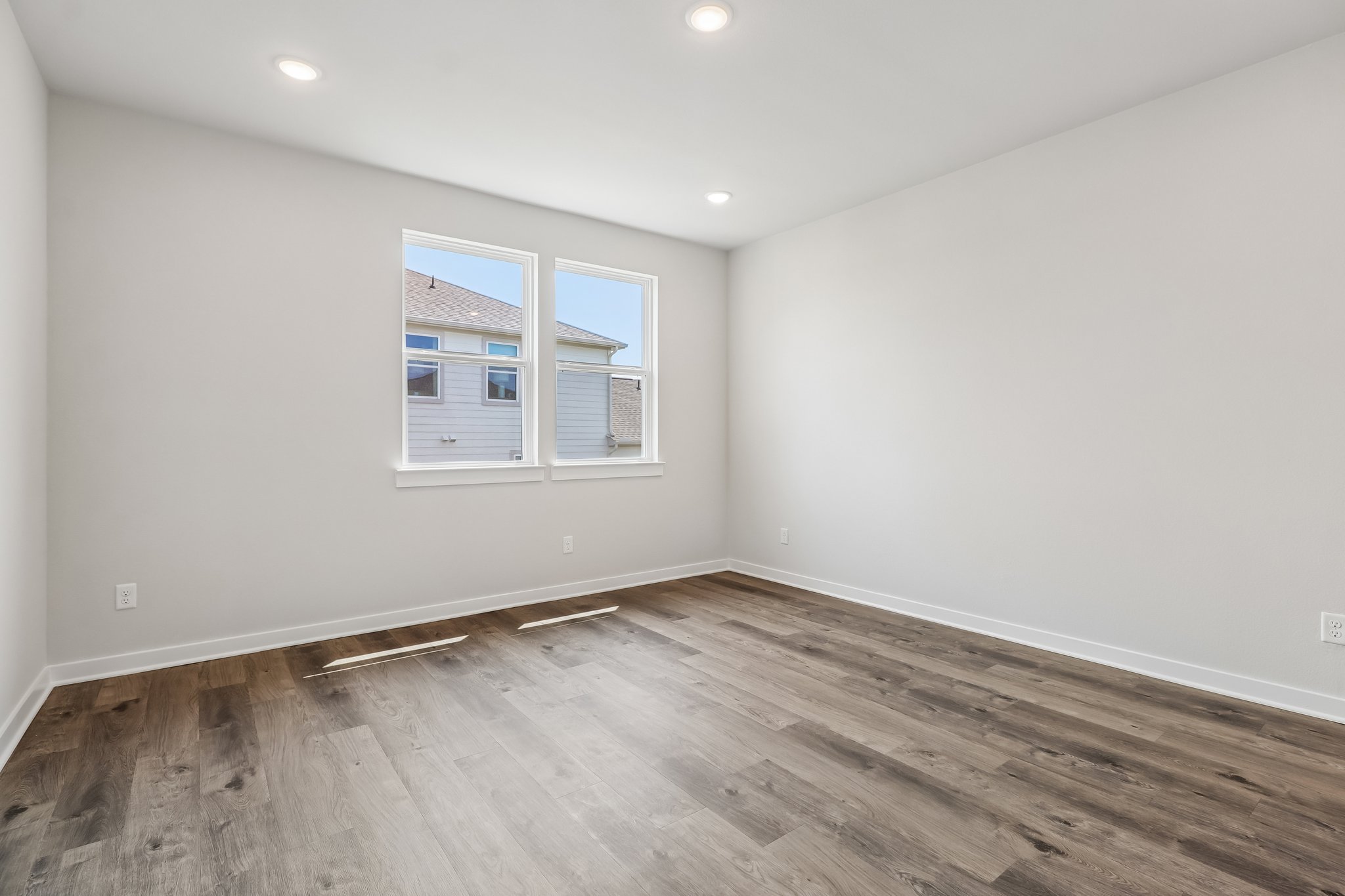 A room with a wood floor and a window.