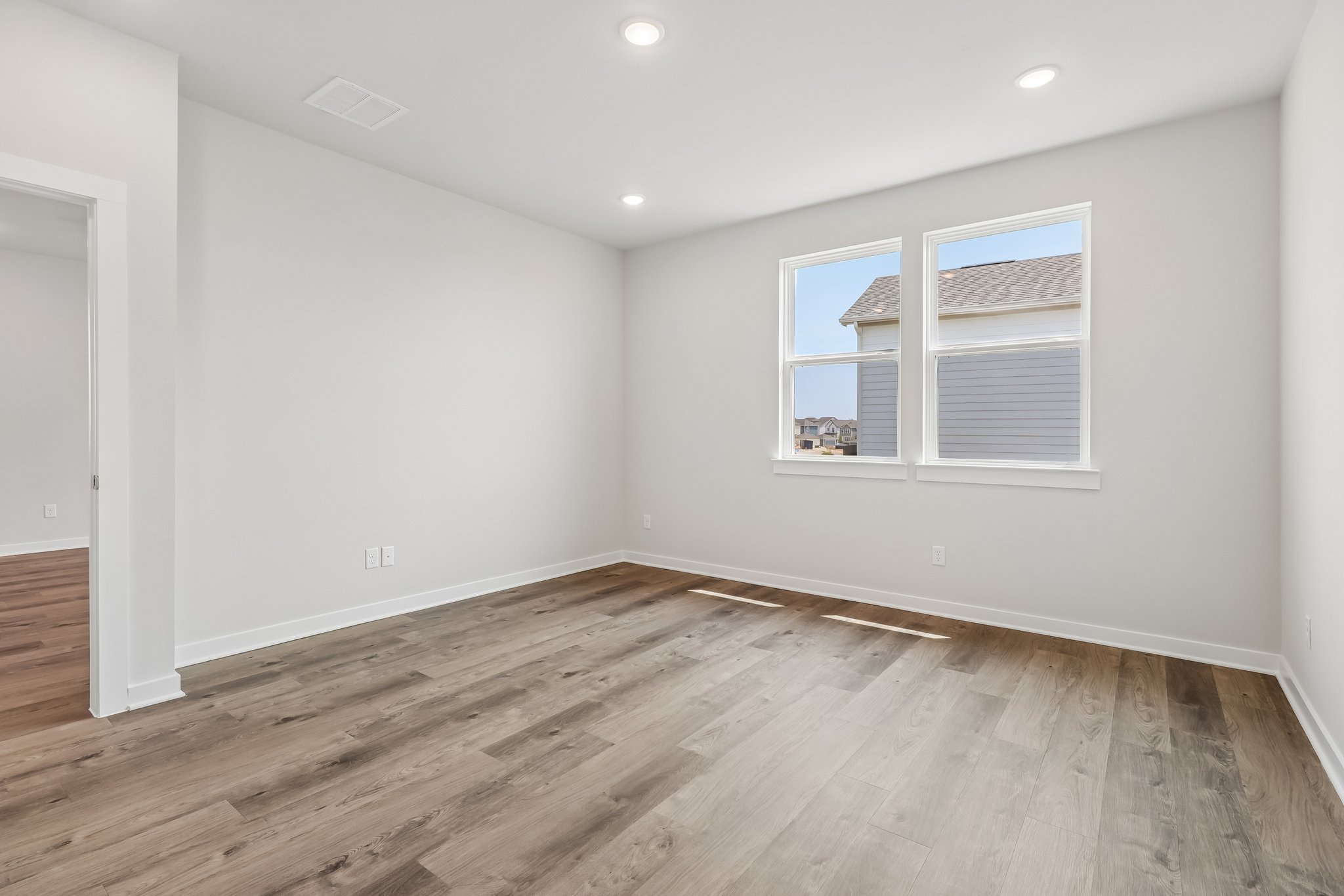 A room with a wood floor and a window.