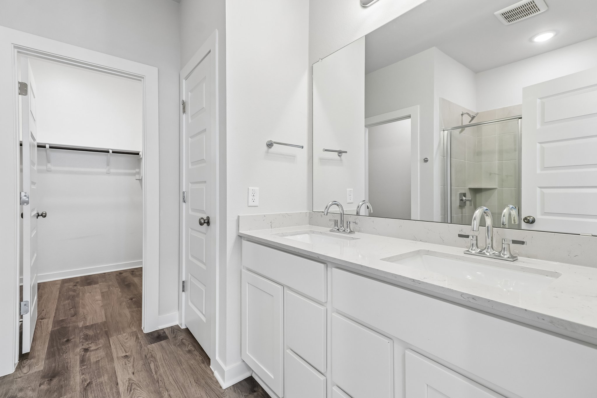 A bathroom with white cabinets.