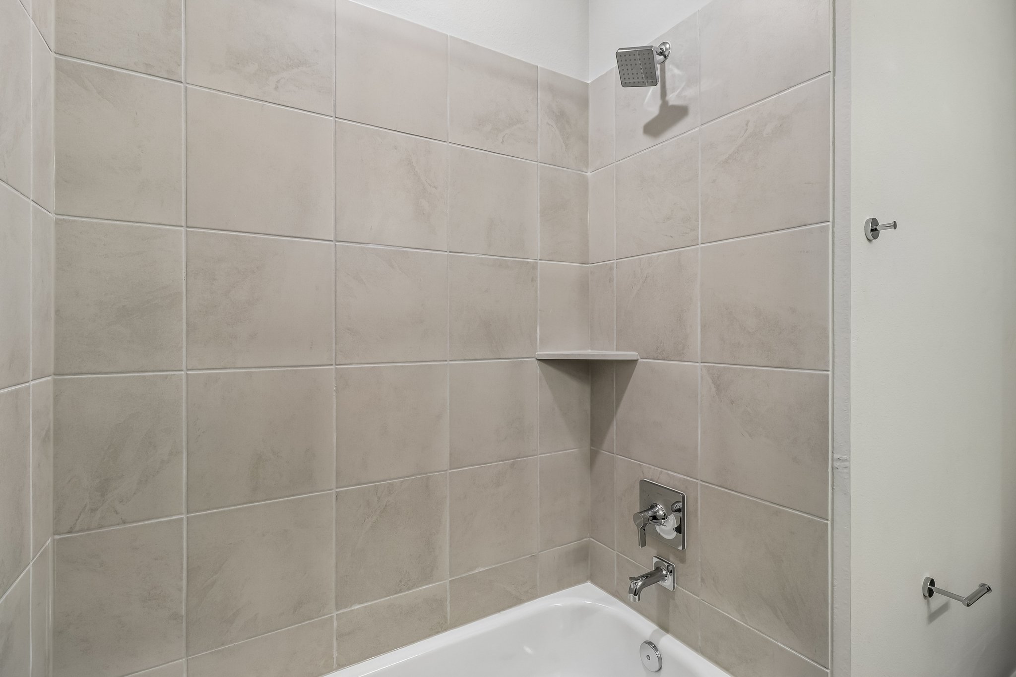 A bathroom with a tile wall.