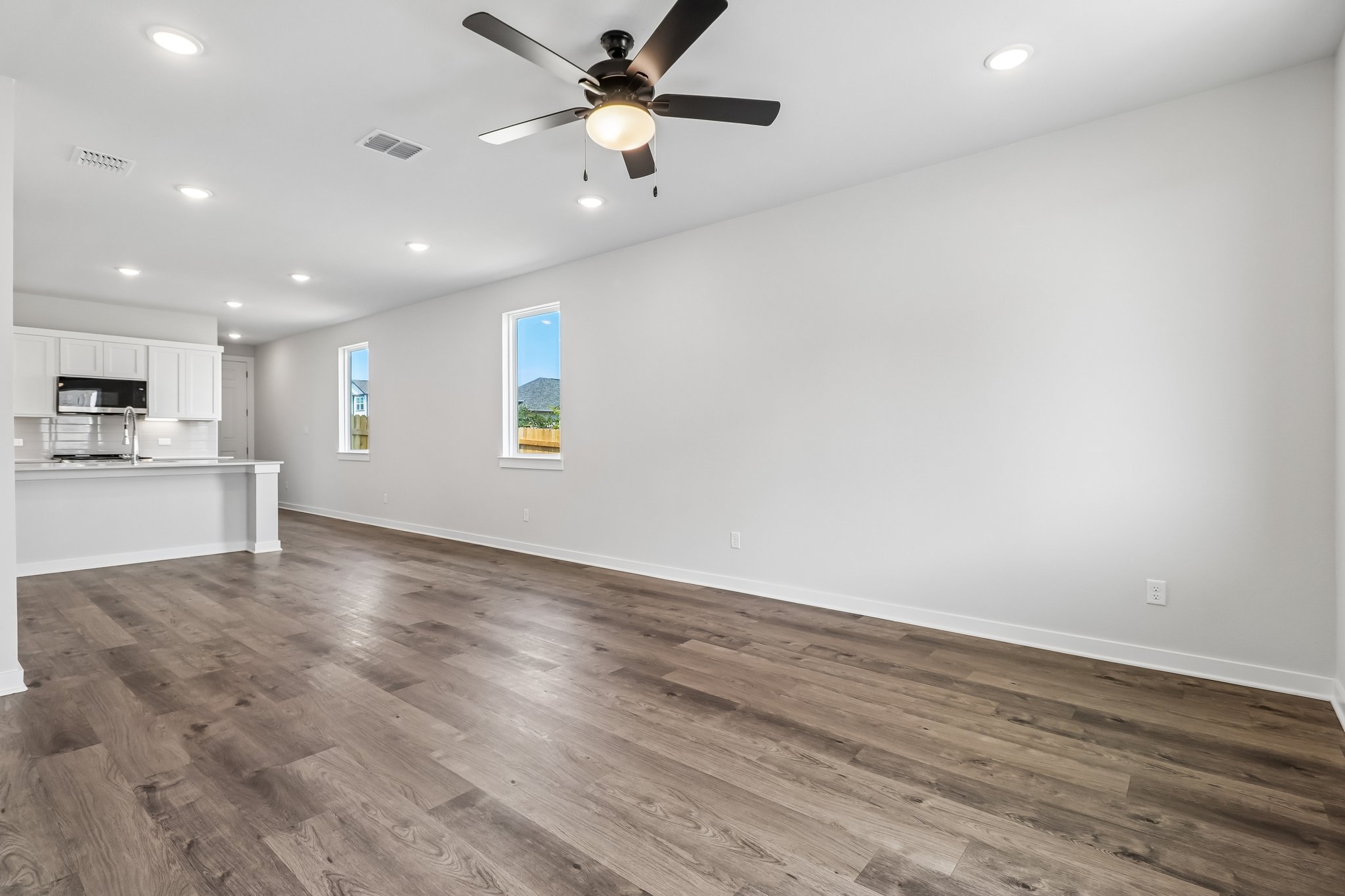 A room with a wood floor and a ceiling fan.