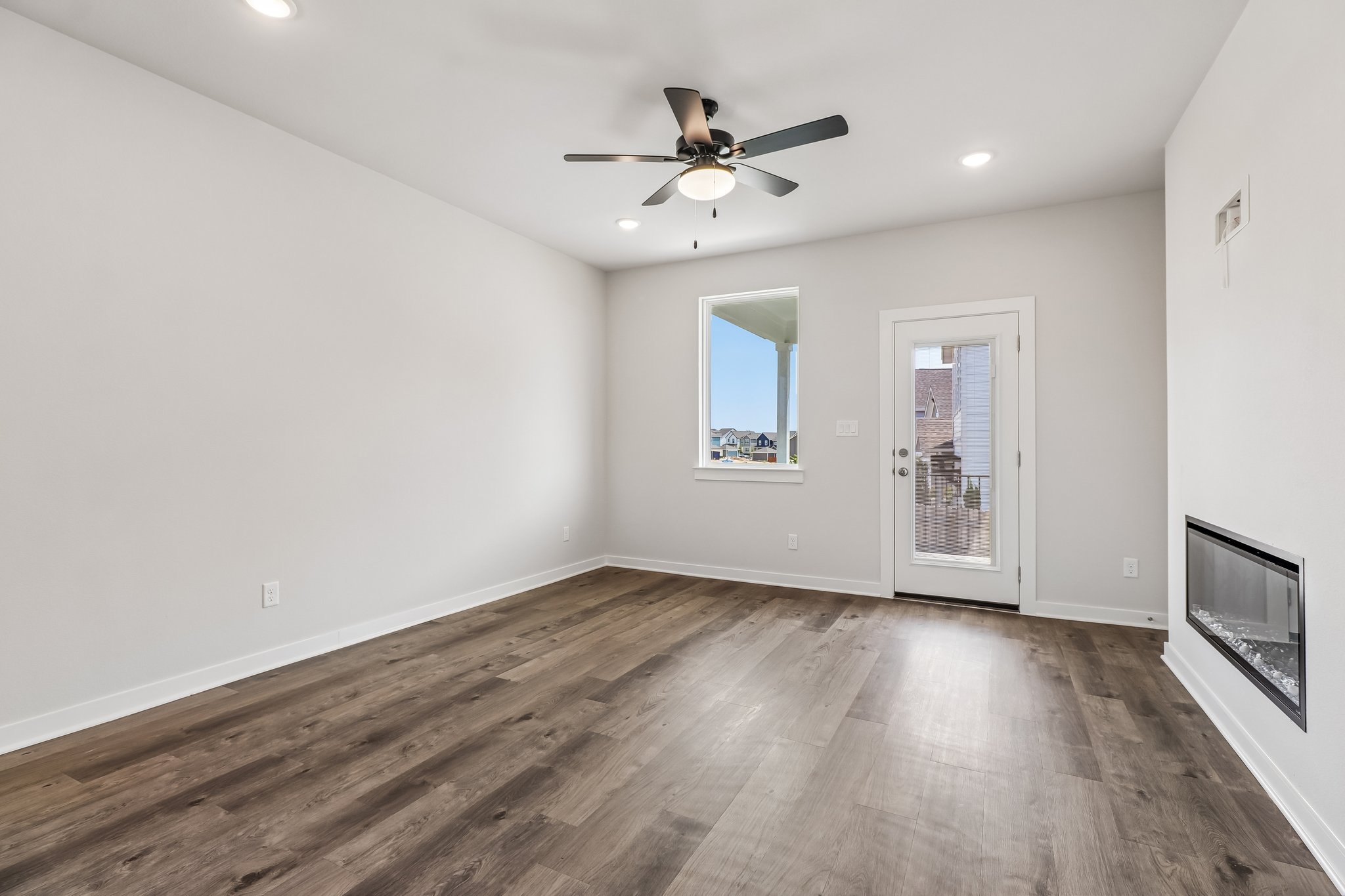 A room with a wood floor and a ceiling fan.