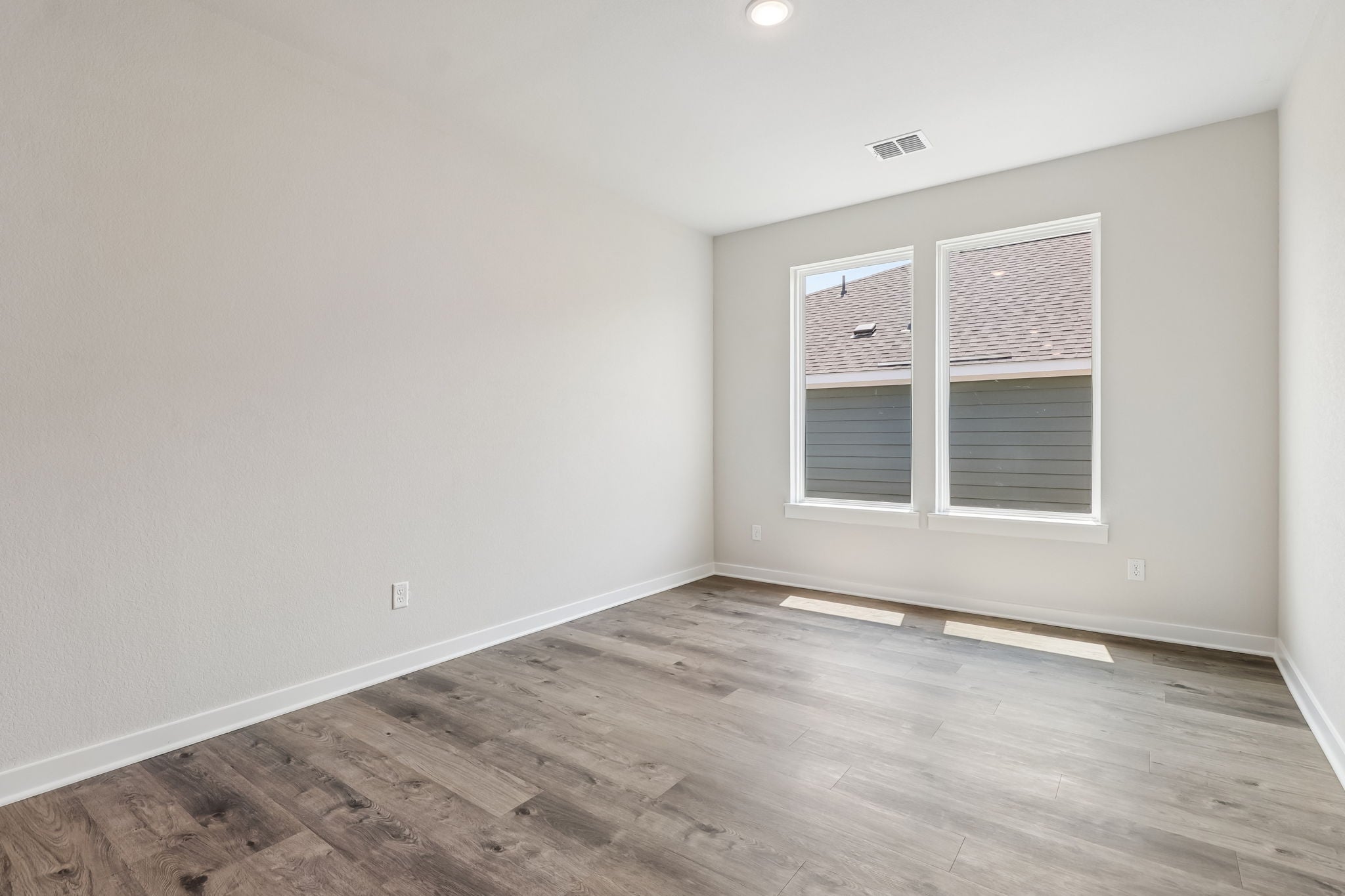 A room with a wood floor and a window.