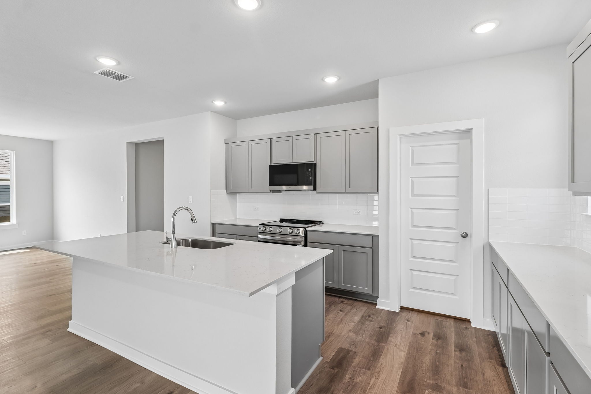 A kitchen with white cabinets.