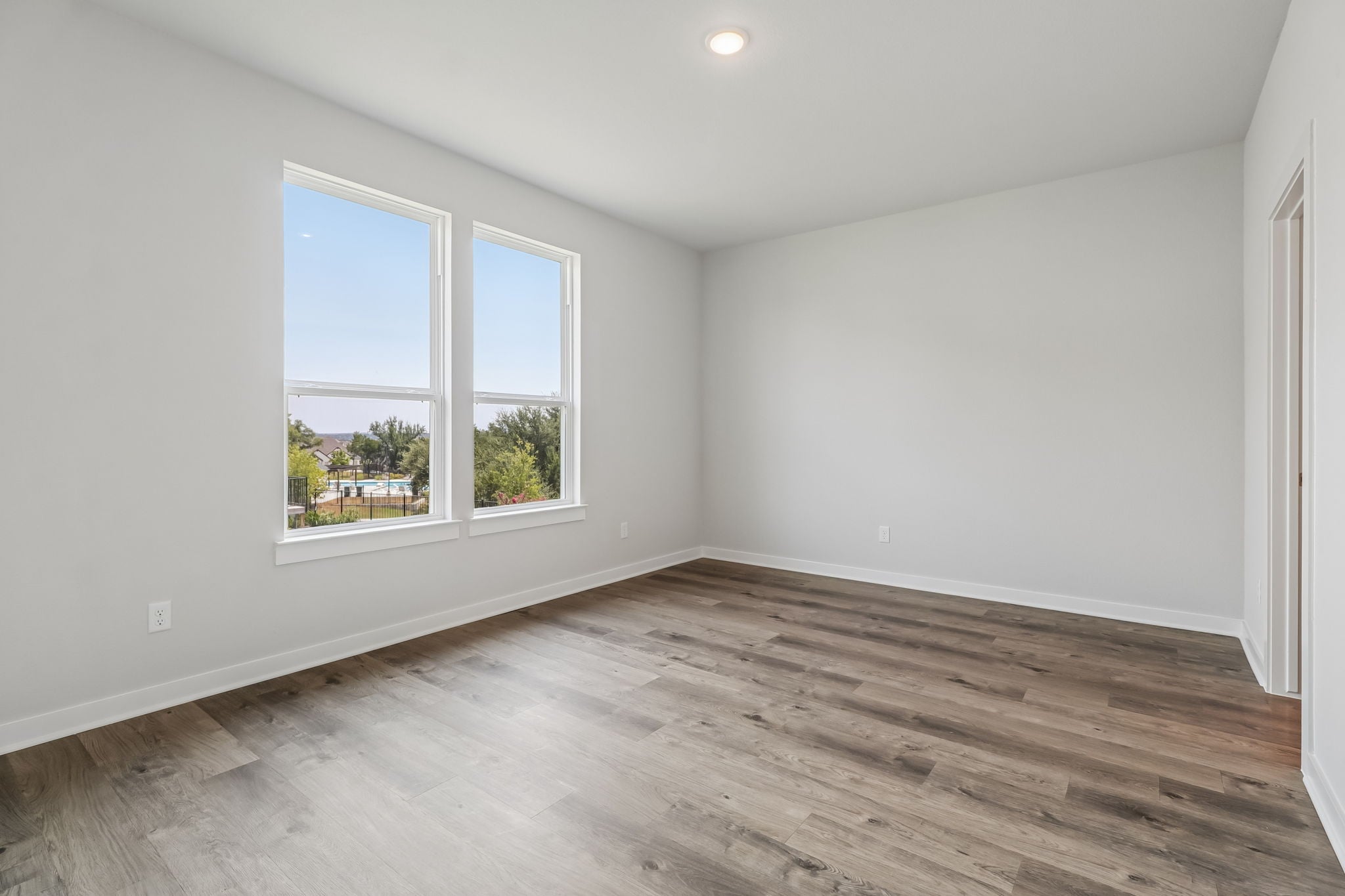 A room with a wood floor and windows.