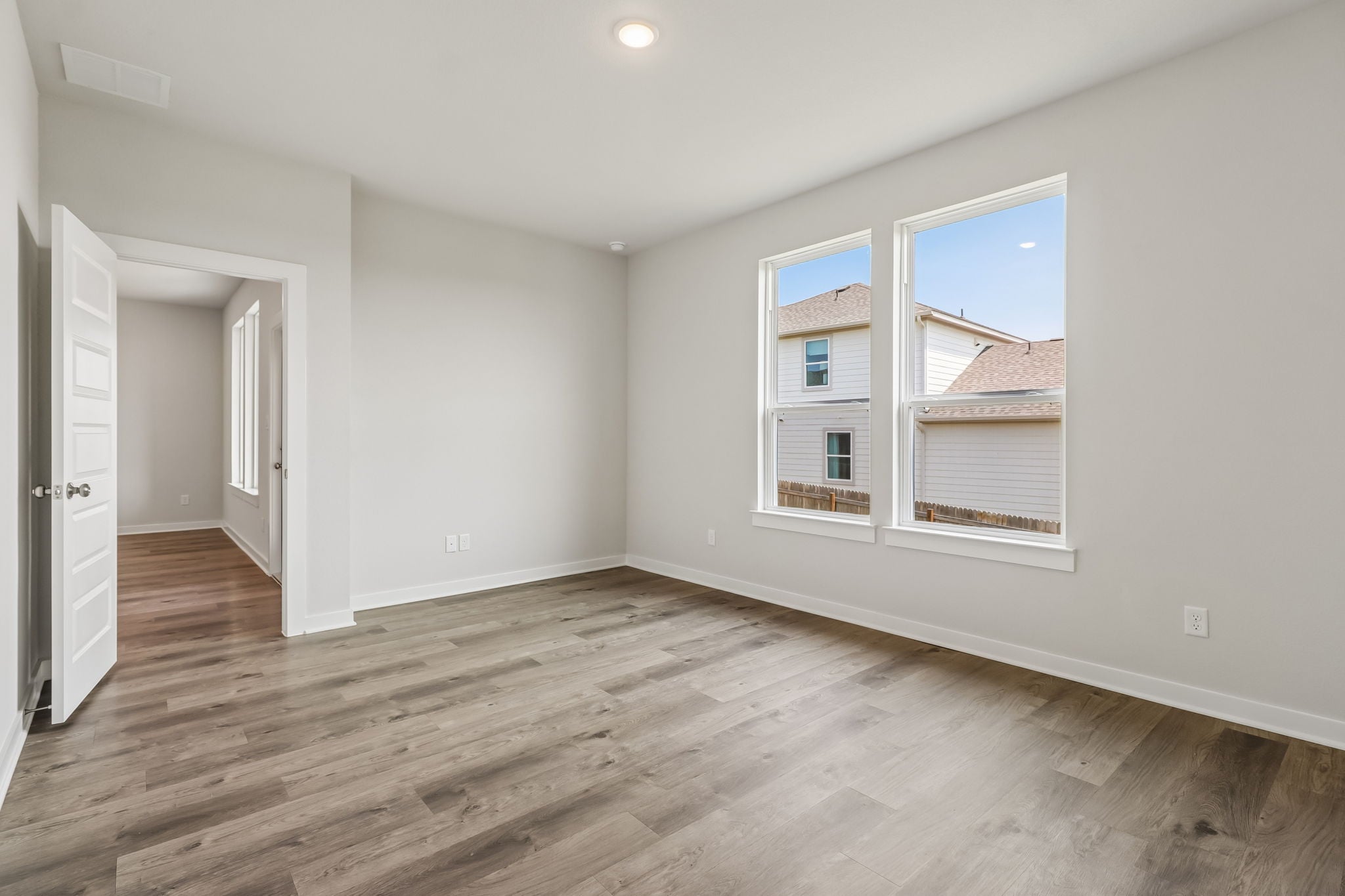 A room with a wood floor and a window.