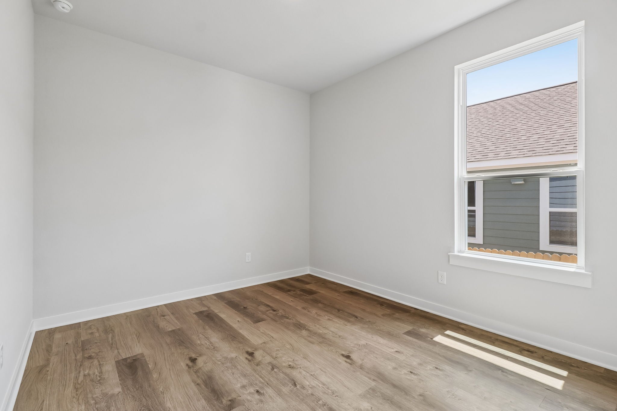 A room with a wood floor and a window.