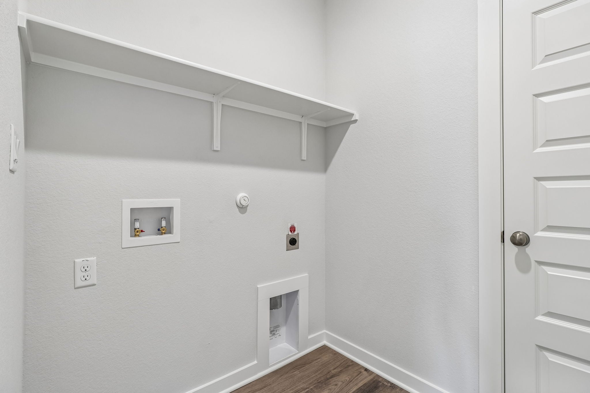 A white wall with a white door.