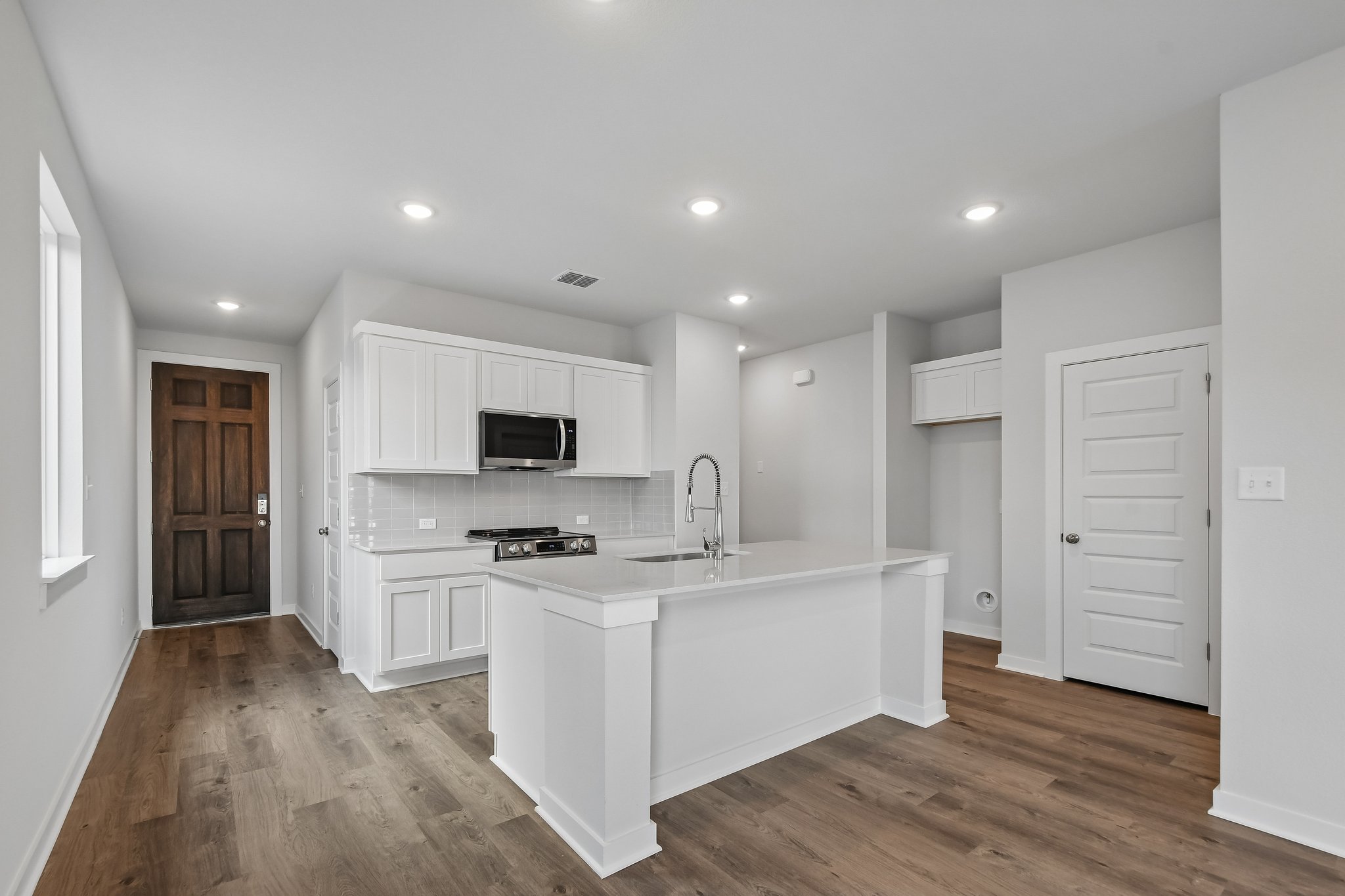 A kitchen with white cabinets.