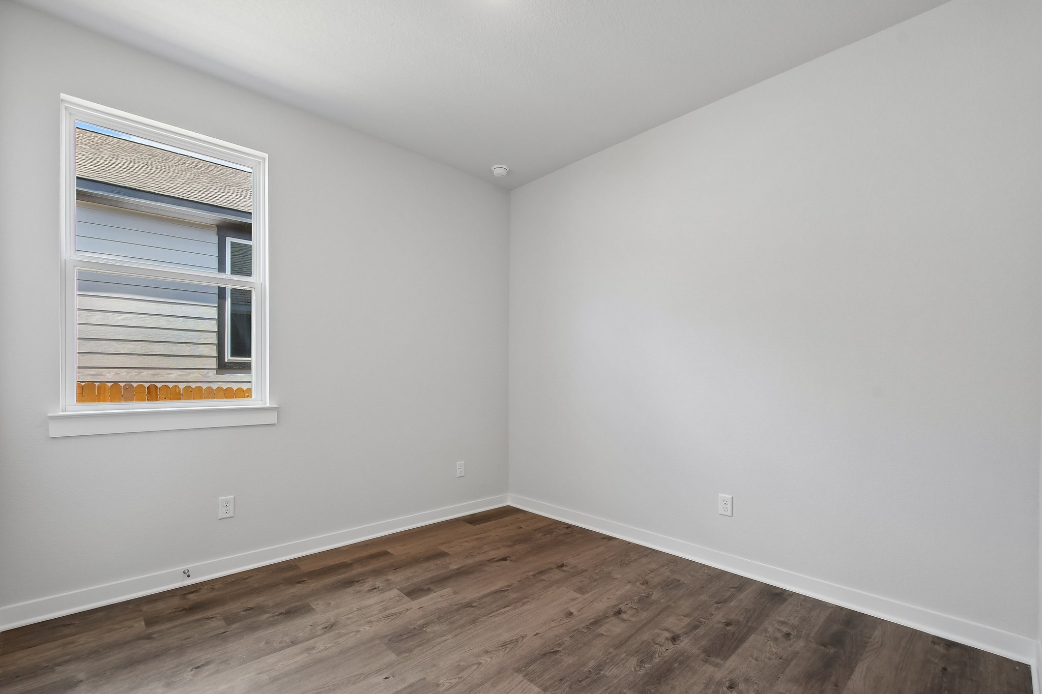 A room with a wood floor and a window.