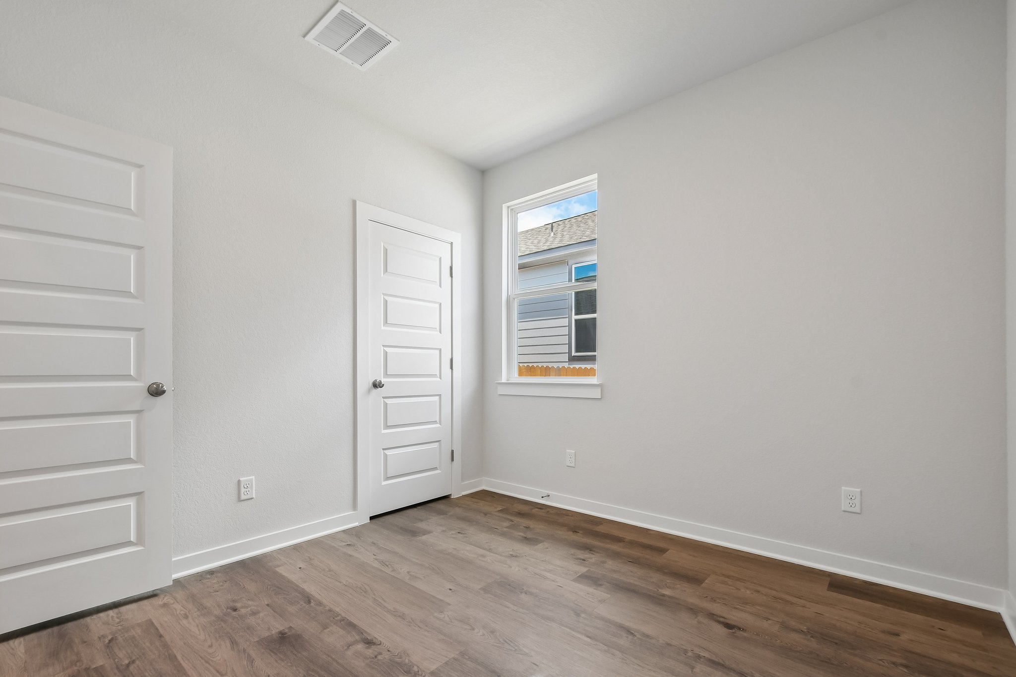A room with white walls and a wood floor.