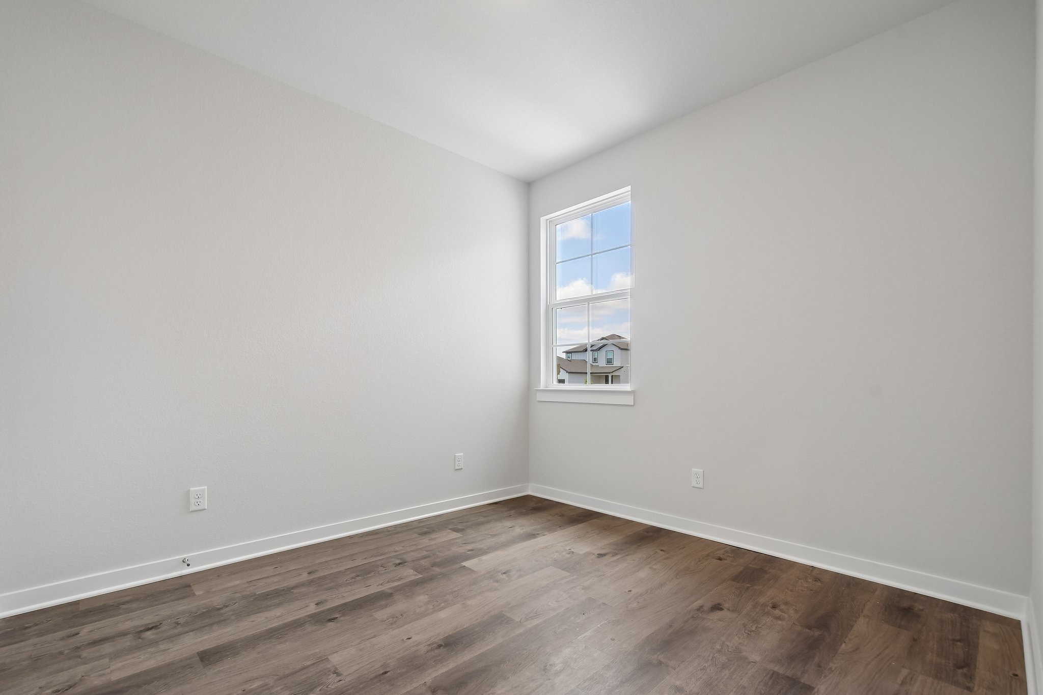 A room with a wood floor and a window.
