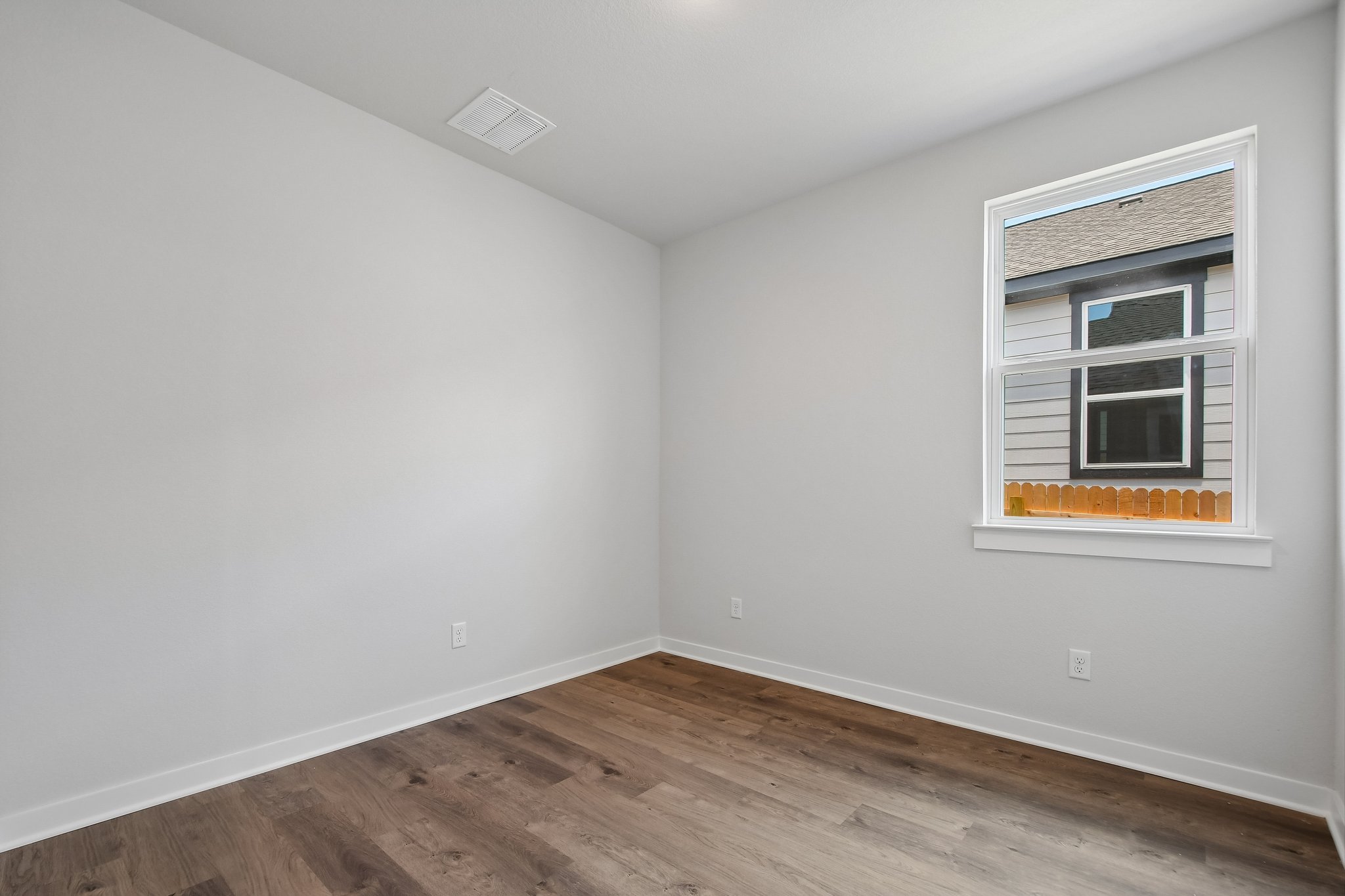 A room with a wood floor and a window.