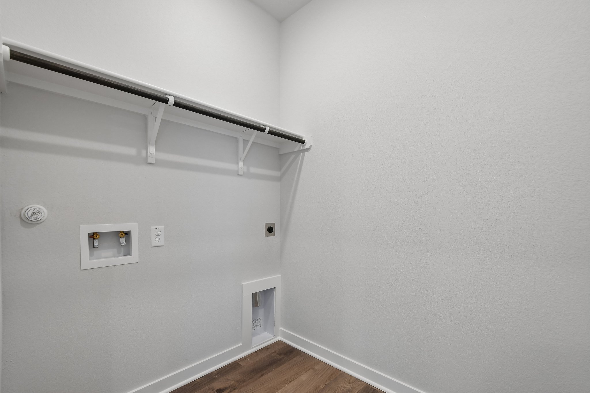 A white room with a wood floor and a wood floor.