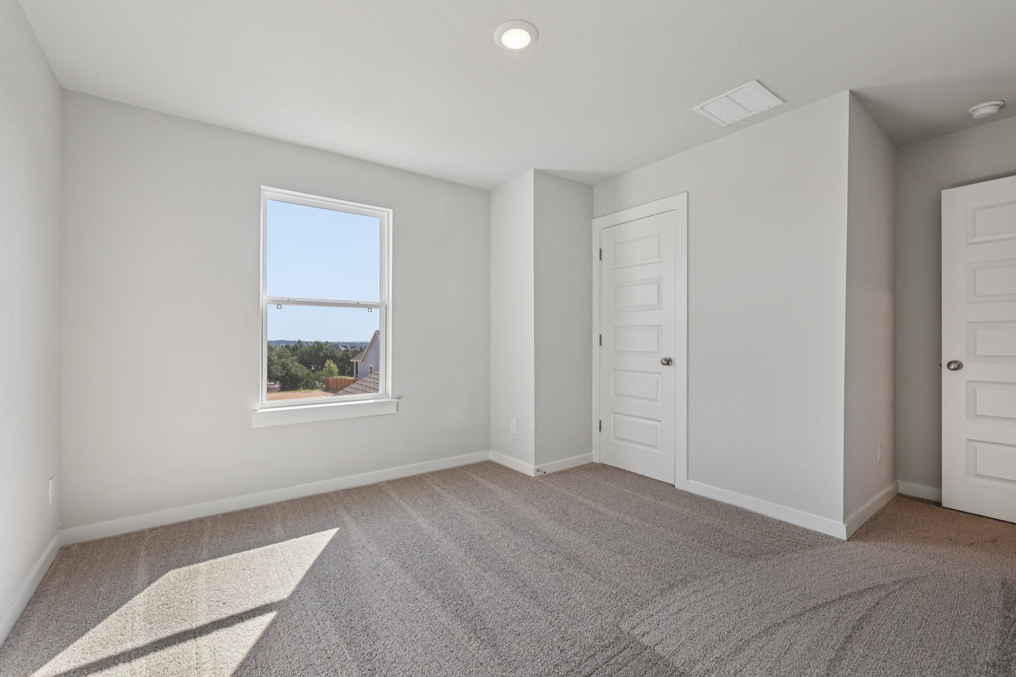 A room with white walls and a window.