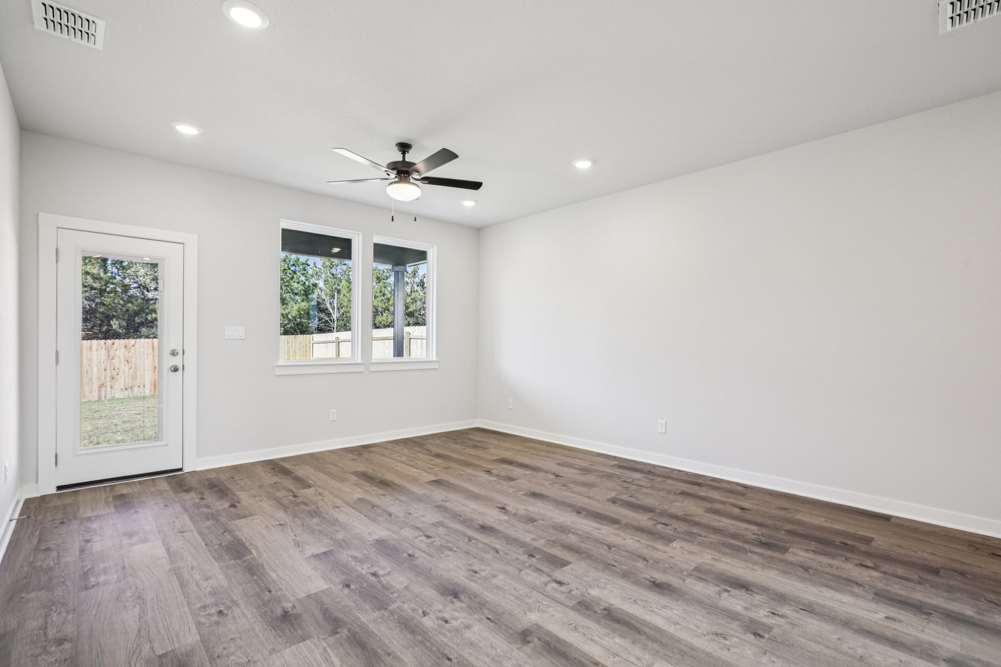 A room with a wood floor and a ceiling fan.