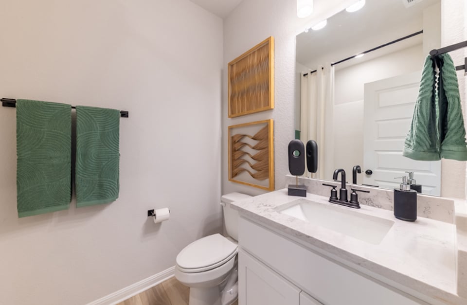 A bathroom with green towels.