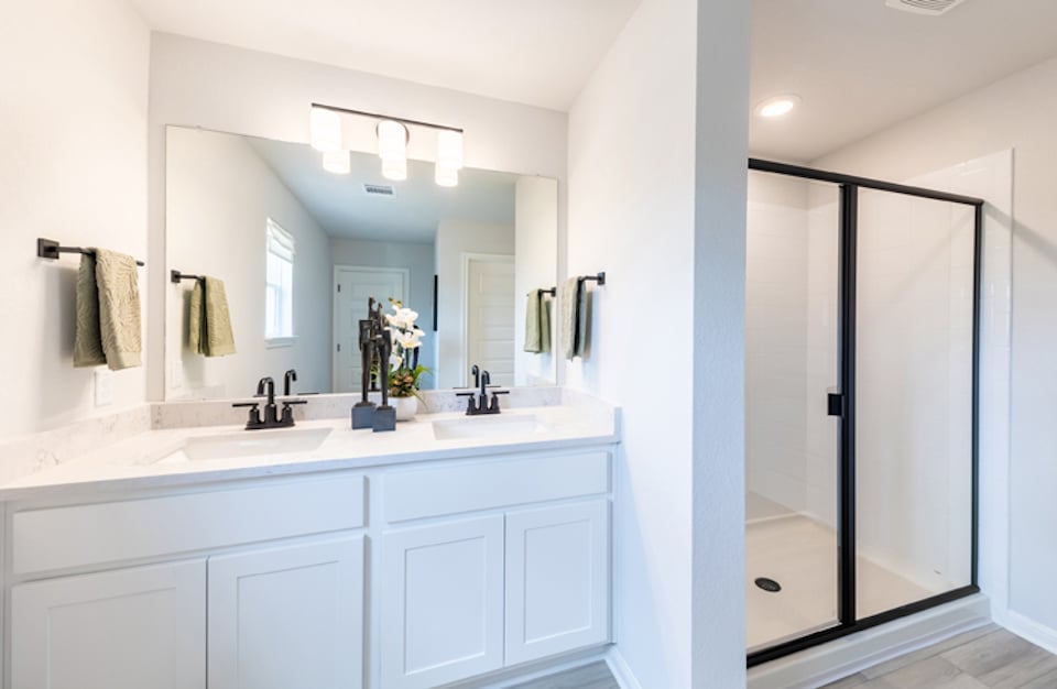 A bathroom with a sink and a shower unit.