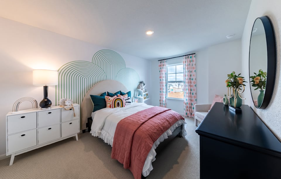 A bedroom with a bed and a mirror.