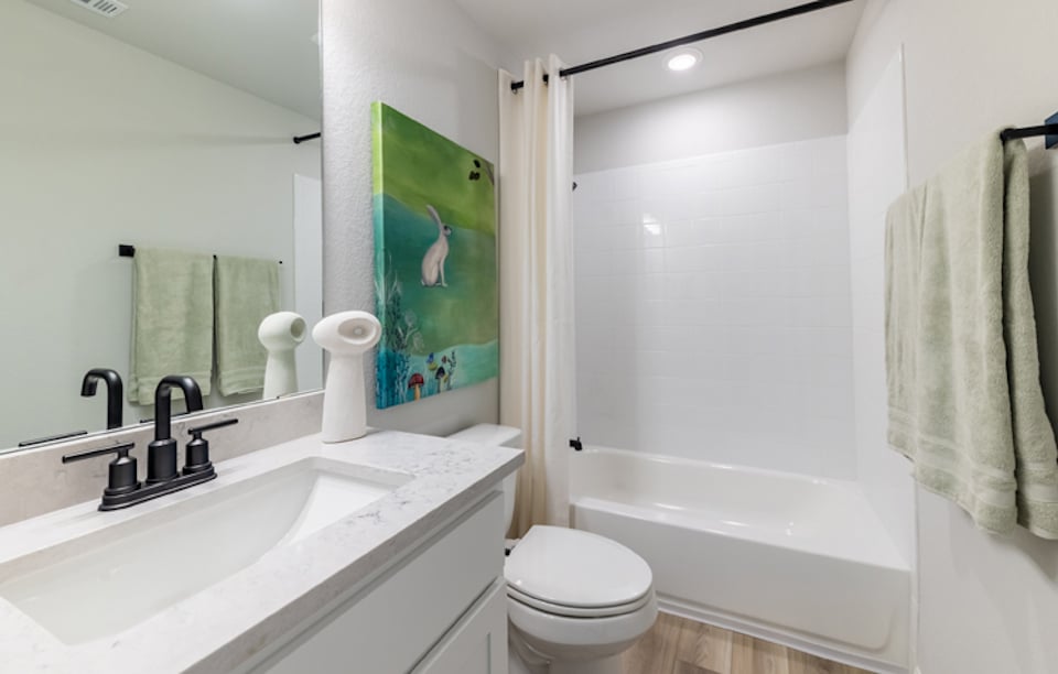 A bathroom with a sink toilet and bathtub.