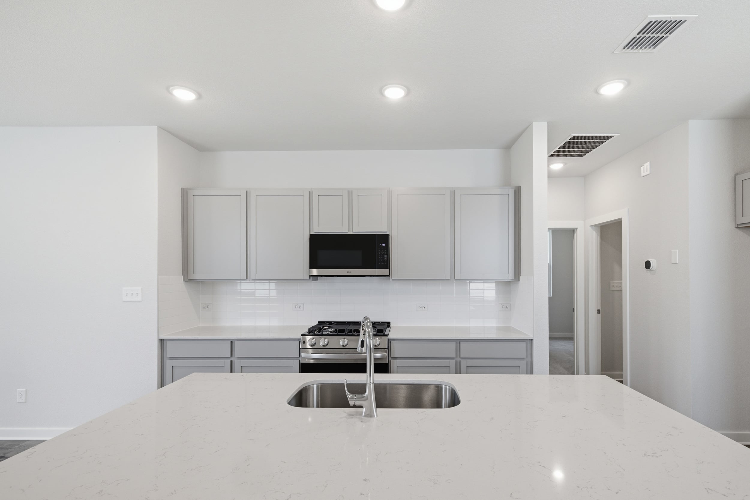 A kitchen with white cabinets.