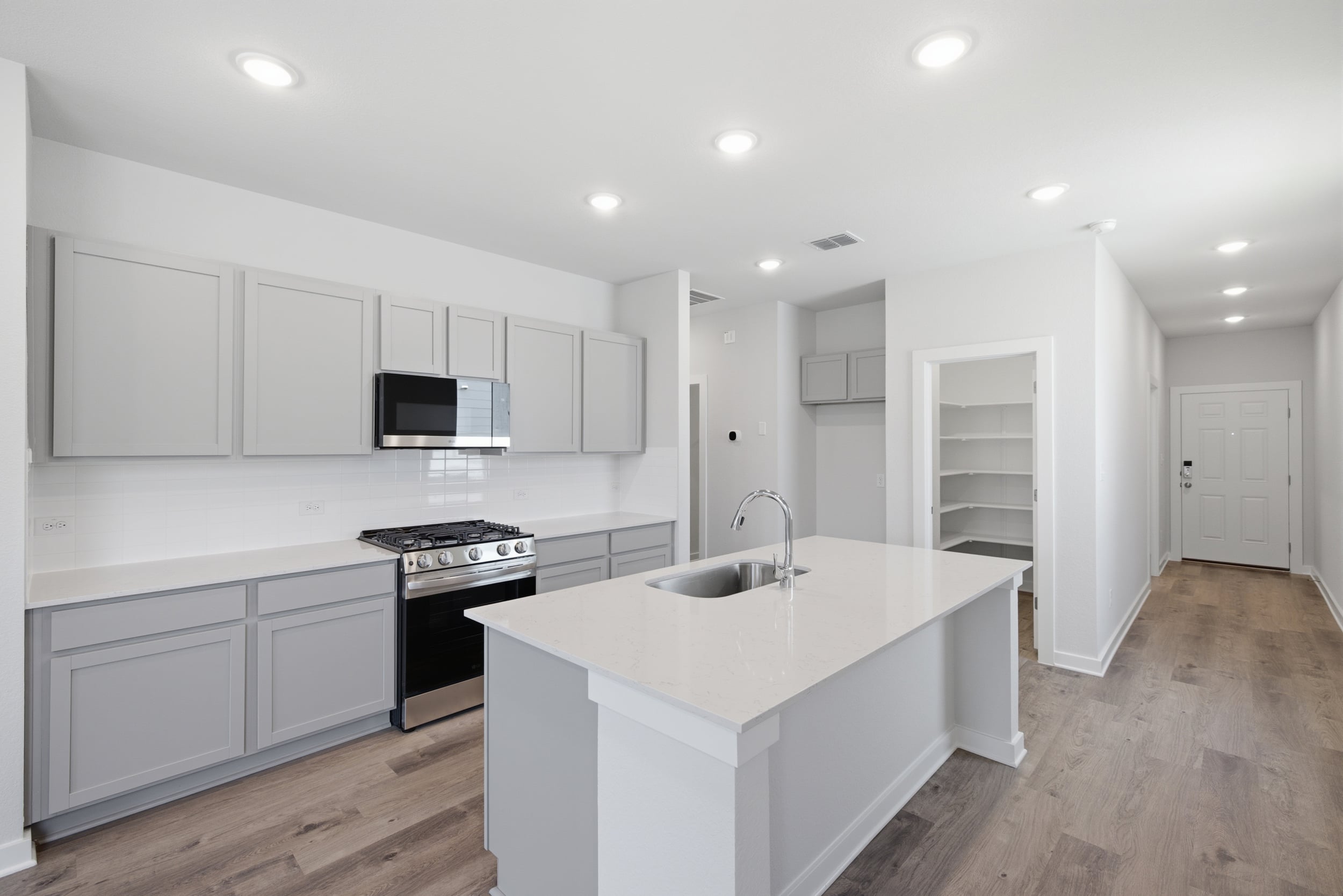 A kitchen with white cabinets.