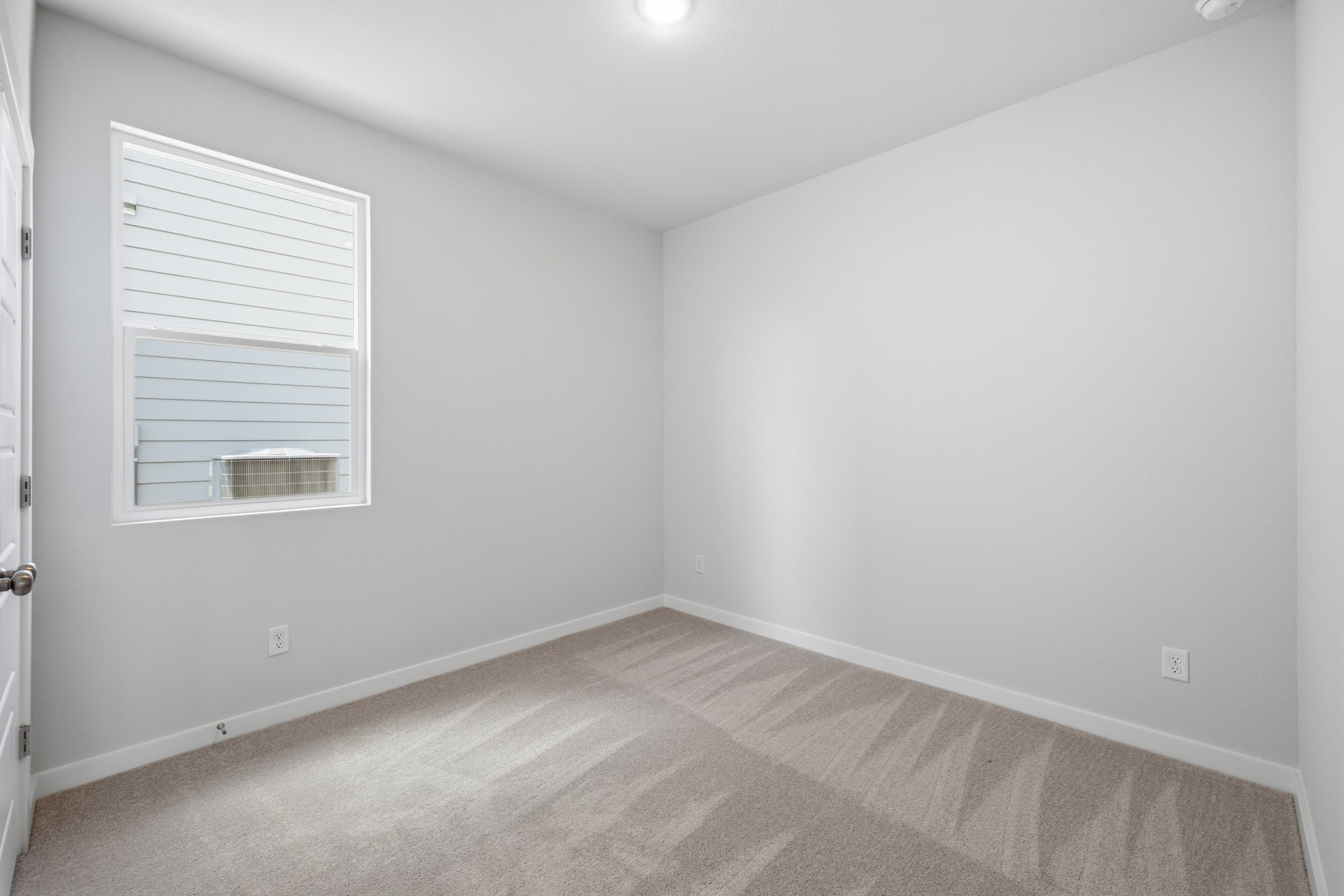 A room with a carpet and a window.